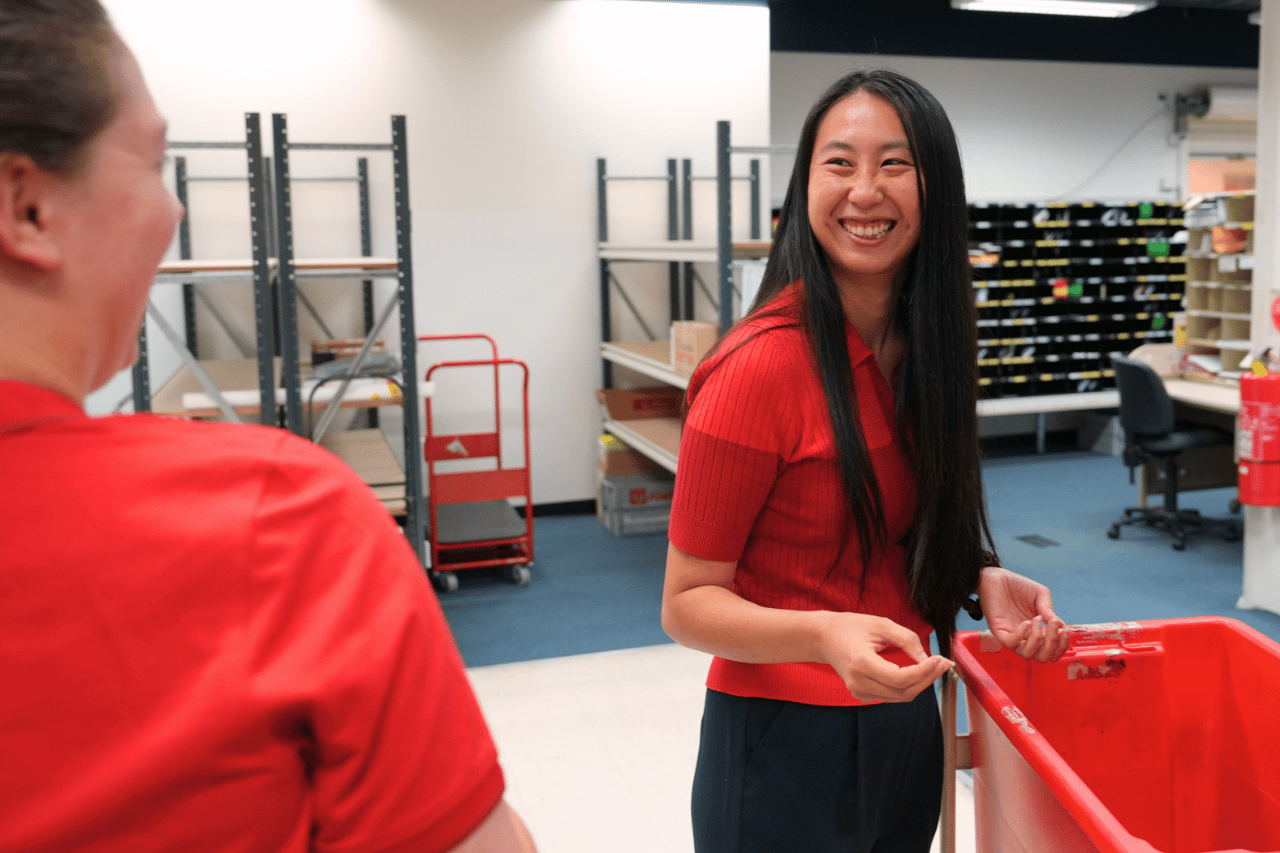 Two team members smiling at each other in the back room of a retail store