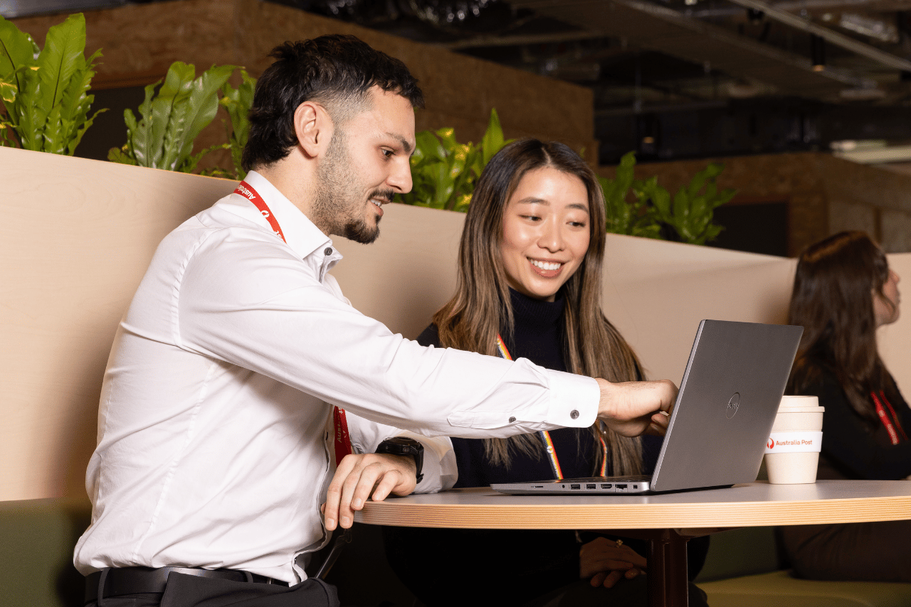Team members sitting in a communal area looking at a laptop