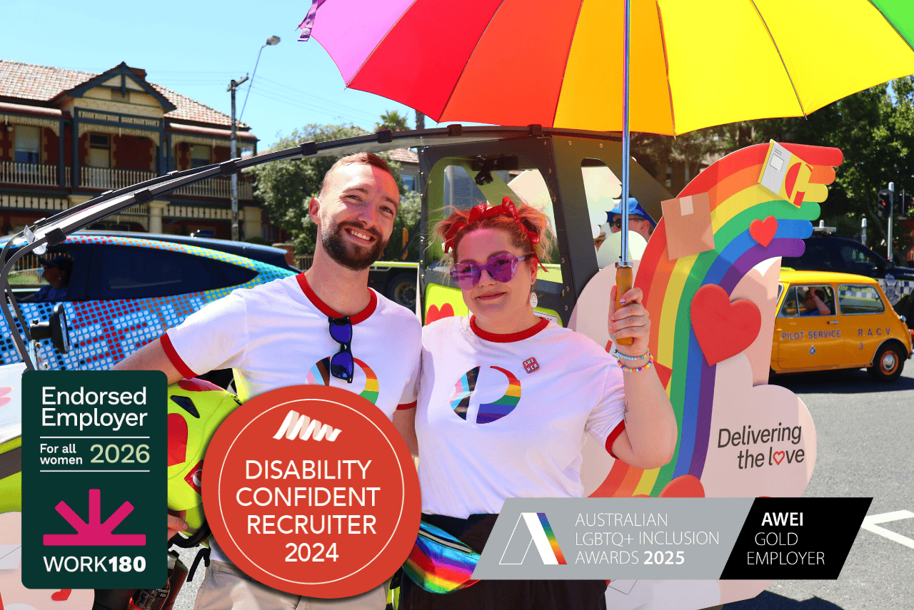 An office team member in a wheelchair smiles to the side. Overlayed images read ‘Disability confident recruiter 2023’ and ‘Australian LGBTQ Inclusion Awards 2023-2026’.